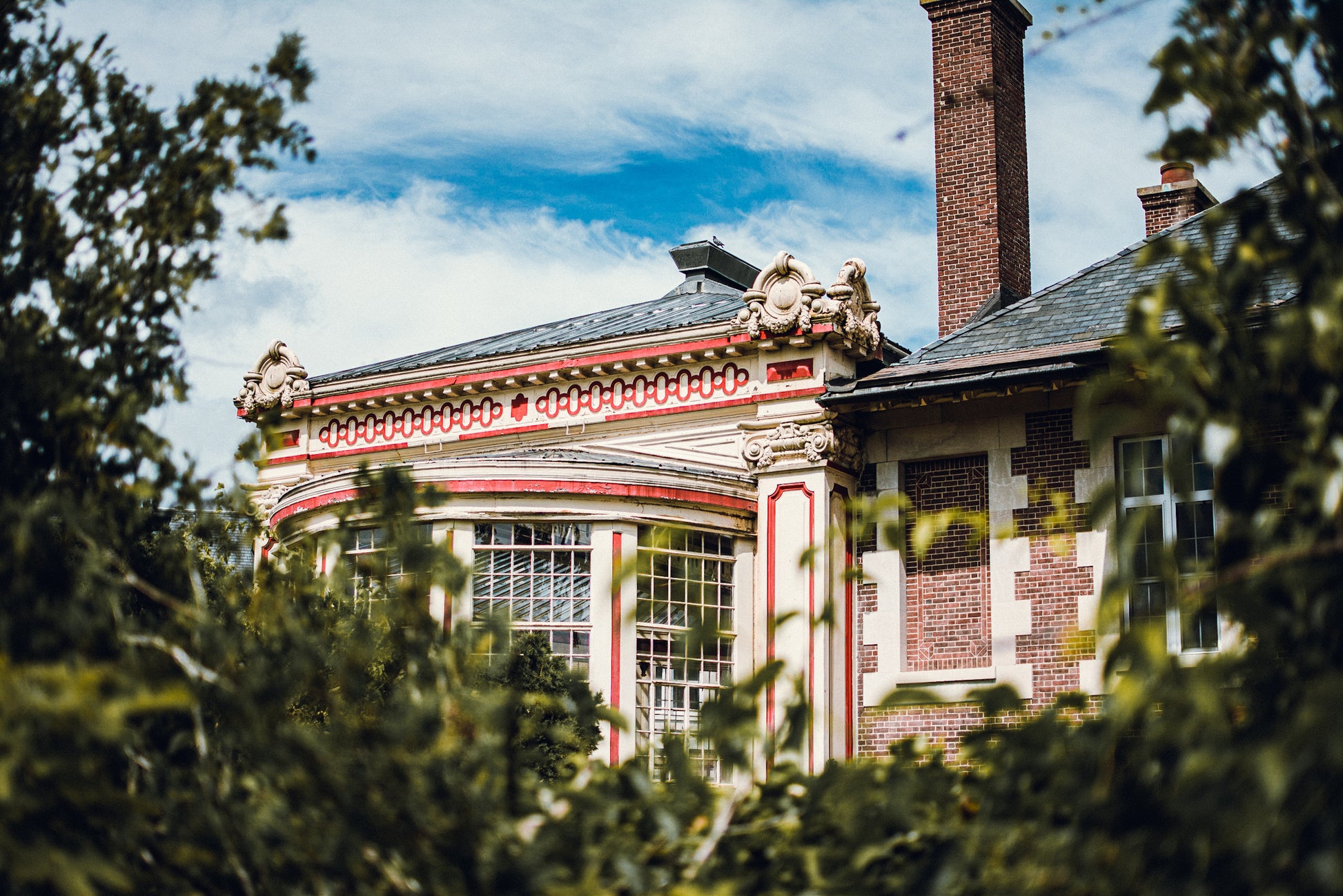 Historic building with decorative architecture framed by greenery
