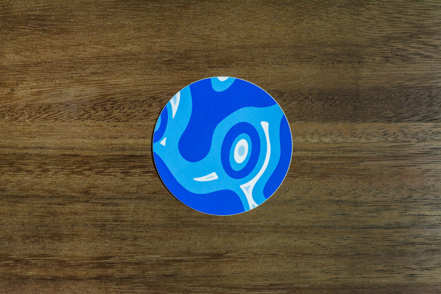 Blue abstract 3” sticker on wood surface