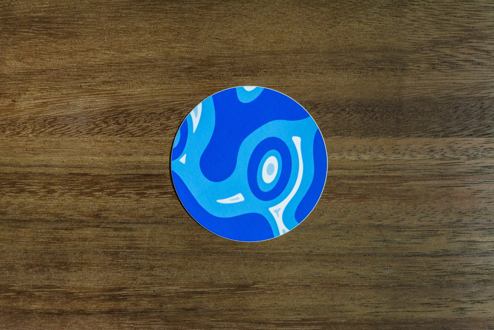Blue abstract 3” sticker on wood surface