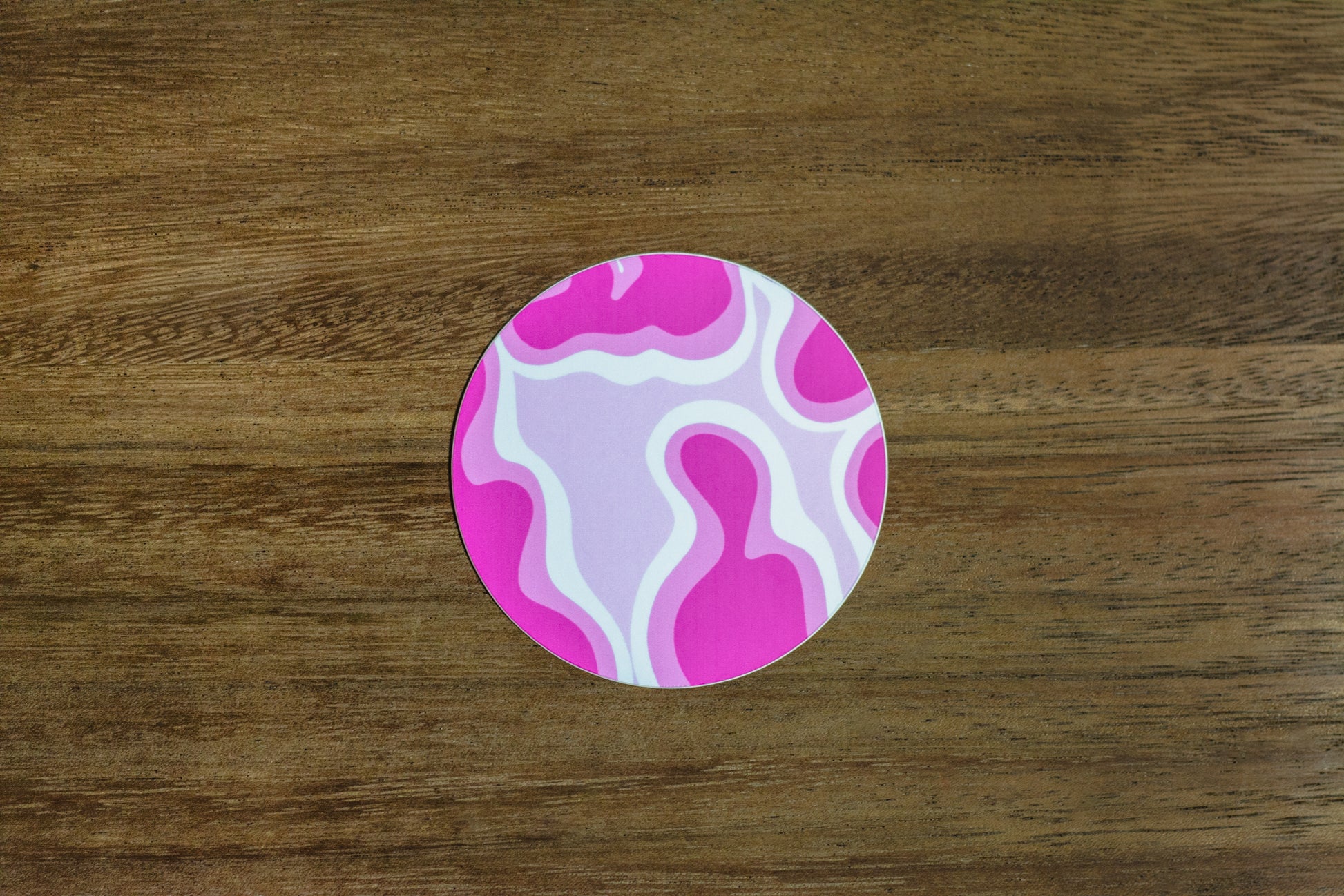 Pink abstract 3” sticker on wood surface