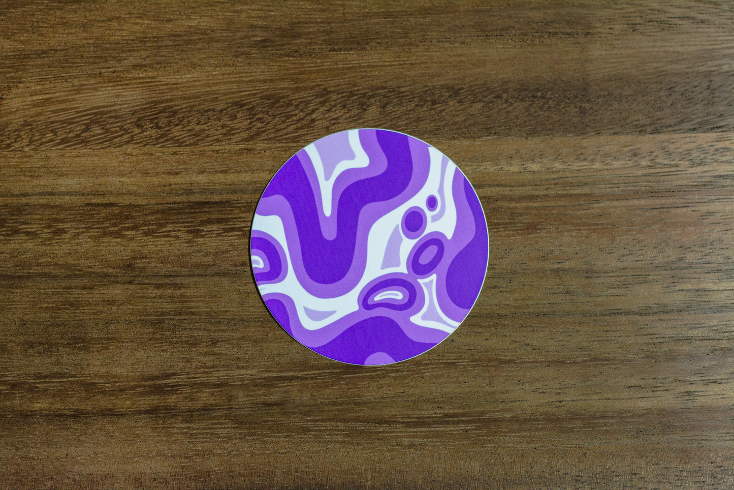 Purple abstract 3” sticker on wood surface