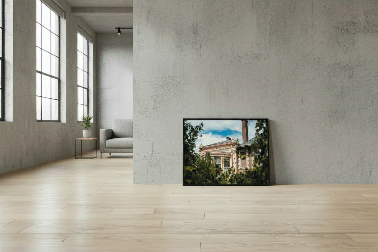 fine art photo print in black frame leaning against concrete wall in modern loft
